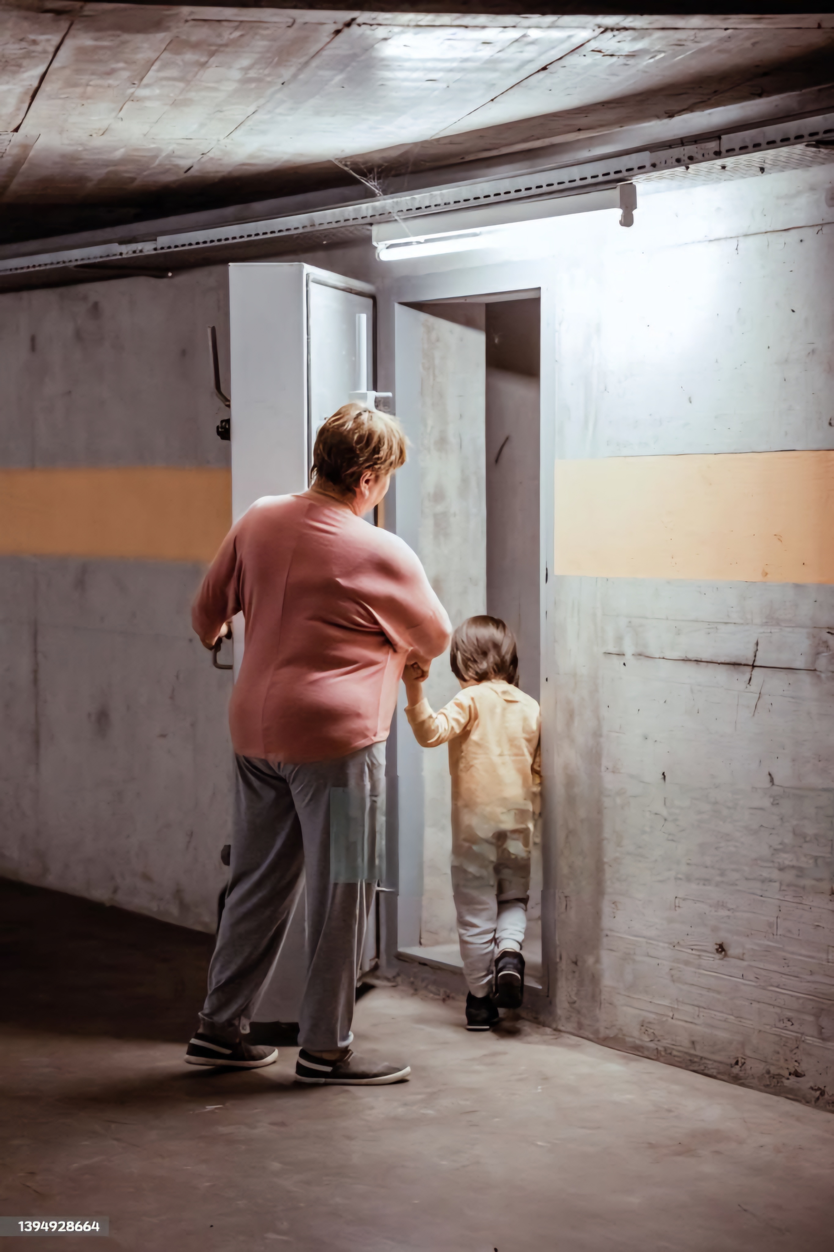 Une dame et un enfant rentrant dans un bunker